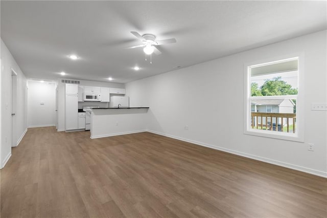 719 E Culton St, Warrensburg, MO 64093 - unfurnished living room featuring ceiling fan, wood finished floors, and recessed lighting