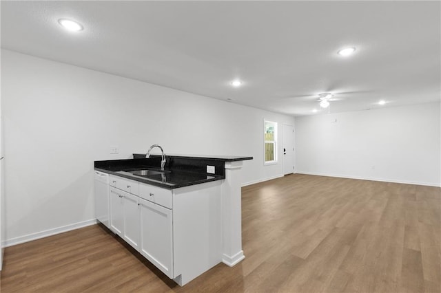 719 E Culton St, Warrensburg, MO 64093 - kitchen featuring a peninsula, ceiling fan, wood finished floors, white cabinets, and open floor plan