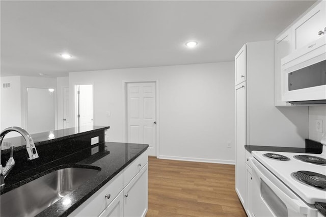 719 E Culton St, Warrensburg, MO 64093 - kitchen with white appliances, white cabinetry, light wood-style flooring, recessed lighting, and dark stone counters