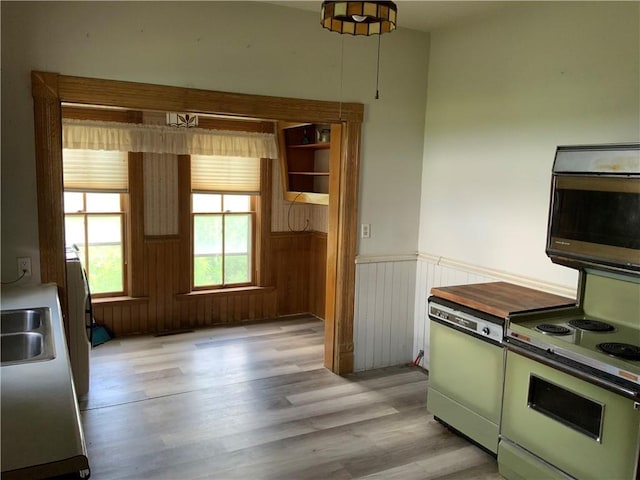 627 50th Rd, Toronto, KS 66777 - kitchen with dishwasher, stainless steel microwave, wainscoting, light wood-type flooring, and electric range oven