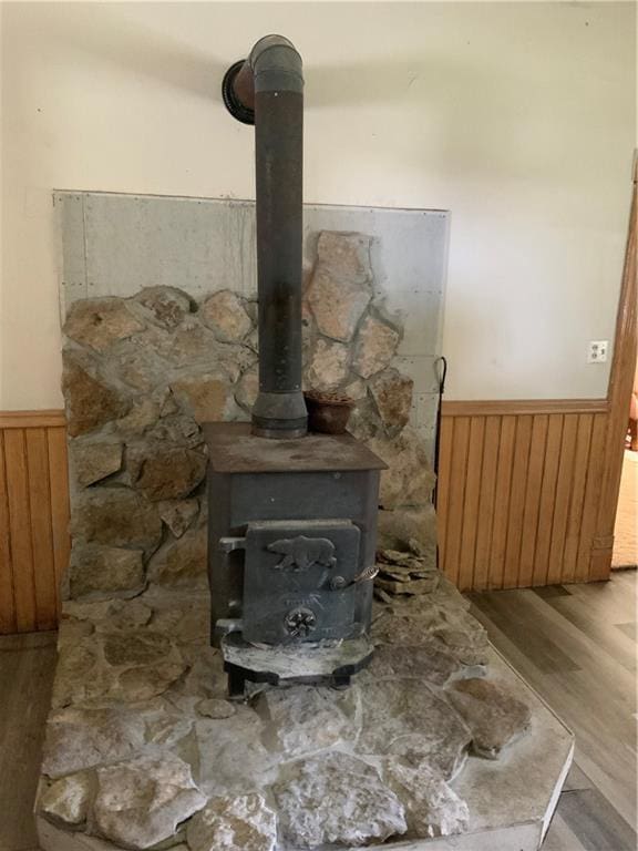 627 50th Rd, Toronto, KS 66777 - detailed view of wainscoting, wood finished floors, a wood stove, and wood walls