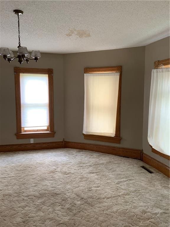 627 50th Rd, Toronto, KS 66777 - unfurnished room featuring a chandelier, a textured ceiling, and light carpet