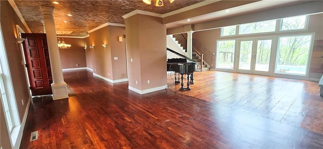 789 Maple Rd, Uniontown, KS 66779 - unfurnished living room with decorative columns, hardwood / wood-style floors, stairway, crown molding, and a chandelier
