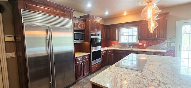 789 Maple Rd, Uniontown, KS 66779 - kitchen with appliances with stainless steel finishes, backsplash, hanging light fixtures, recessed lighting, and dark brown cabinetry
