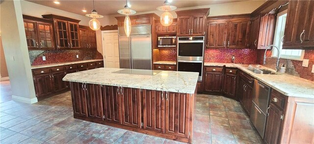 789 Maple Rd, Uniontown, KS 66779 - kitchen featuring appliances with stainless steel finishes, decorative backsplash, a kitchen island, glass insert cabinets, and light stone countertops