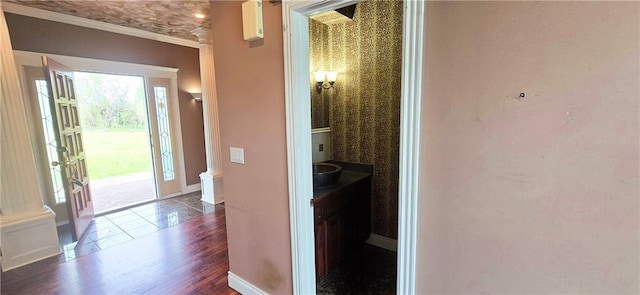 789 Maple Rd, Uniontown, KS 66779 - corridor with ornate columns, dark wood-type flooring, wallpapered walls, and ornamental molding