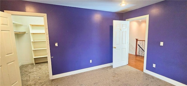 789 Maple Rd, Uniontown, KS 66779 - unfurnished bedroom featuring carpet flooring, a closet, and a walk in closet