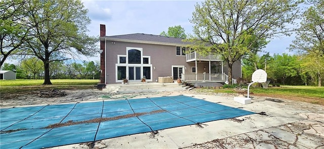 789 Maple Rd, Uniontown, KS 66779 - back of property with a balcony, a chimney, a patio area, a deck, and a covered pool