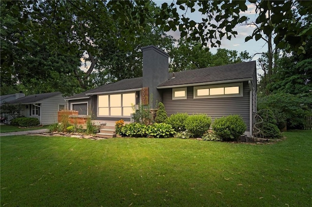 5001 W 70th St, Prairie Village, KS 66208 - rear view of property with a yard, a chimney, and an attached garage
