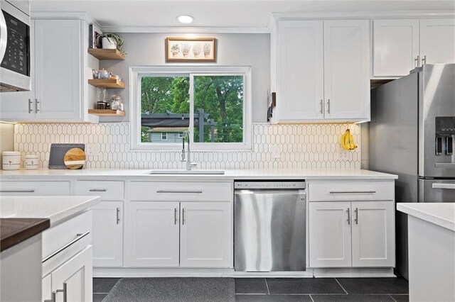 5001 W 70th St, Prairie Village, KS 66208 - kitchen with stainless steel appliances, dark tile patterned floors, white cabinetry, open shelves, and backsplash