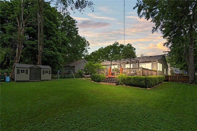 5001 W 70th St, Prairie Village, KS 66208 - yard at dusk with a storage unit, a wooden deck, and a pergola