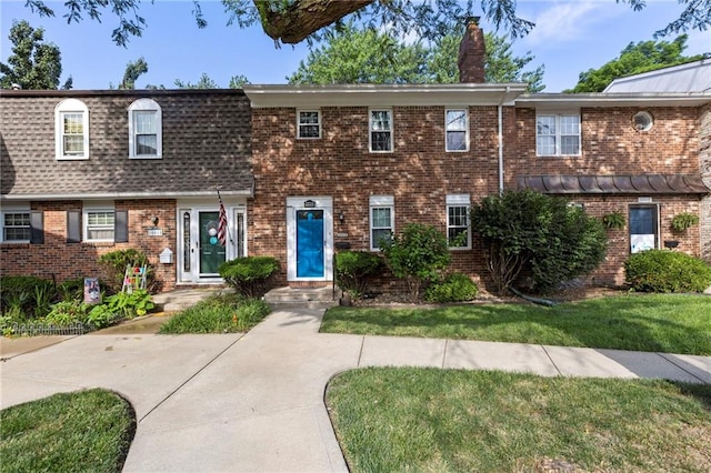 10017 W 95th St, Overland Park, KS 66212 - townhome / multi-family property with a chimney, brick siding, and a front lawn
