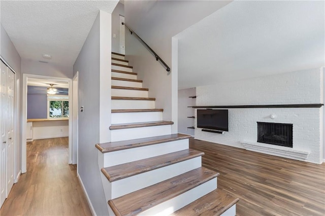 10017 W 95th St, Overland Park, KS 66212 - stairs with a fireplace, wood finished floors, and ceiling fan