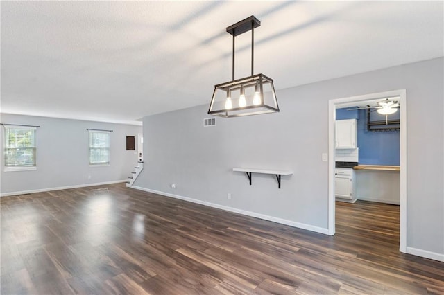 10017 W 95th St, Overland Park, KS 66212 - unfurnished living room with dark wood-style flooring, stairway, and a textured ceiling