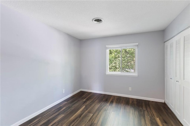 10017 W 95th St, Overland Park, KS 66212 - unfurnished bedroom with a closet, dark wood-style floors, and a textured ceiling