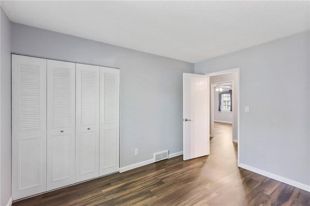 10017 W 95th St, Overland Park, KS 66212 - unfurnished bedroom with dark wood-style flooring and a closet