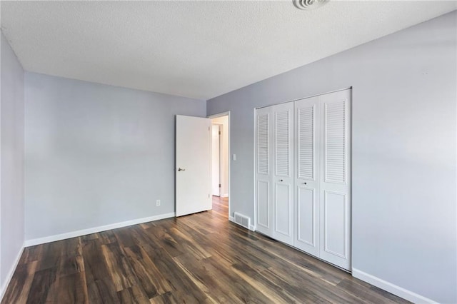 10017 W 95th St, Overland Park, KS 66212 - unfurnished bedroom with dark wood-style floors, a closet, and a textured ceiling