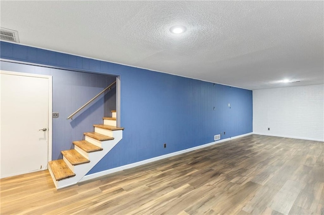 10017 W 95th St, Overland Park, KS 66212 - below grade area with a textured ceiling, wood finished floors, and stairway