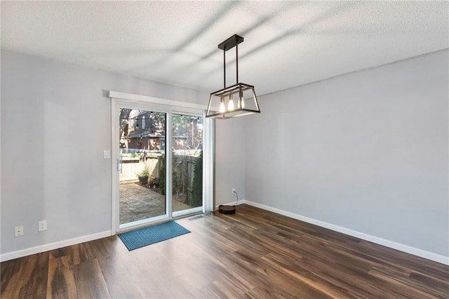 10017 W 95th St, Overland Park, KS 66212 - unfurnished dining area featuring a chandelier, dark wood finished floors, and a textured ceiling