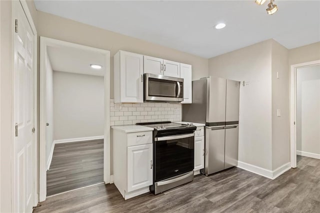 8710 Craig Dr, Overland Park, KS 66212 - kitchen with stainless steel appliances, dark wood-style flooring, white cabinetry, backsplash, and recessed lighting