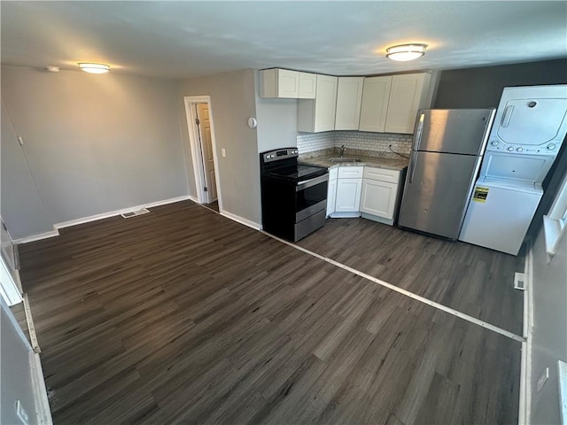 11300 E 29th St, Independence, MO 64052 - kitchen with stainless steel appliances, stacked washing machine and dryer, dark wood-style floors, white cabinets, and decorative backsplash