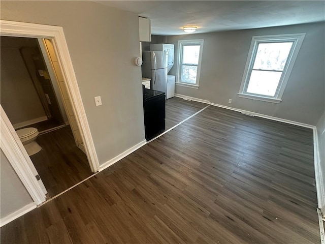 11300 E 29th St, Independence, MO 64052 - unfurnished bedroom featuring freestanding refrigerator and dark wood-style floors
