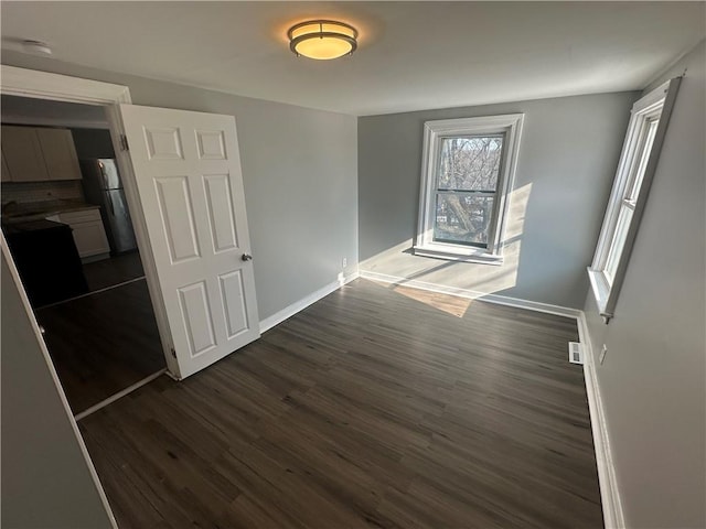 11300 E 29th St, Independence, MO 64052 - unfurnished dining area with dark wood finished floors and baseboards