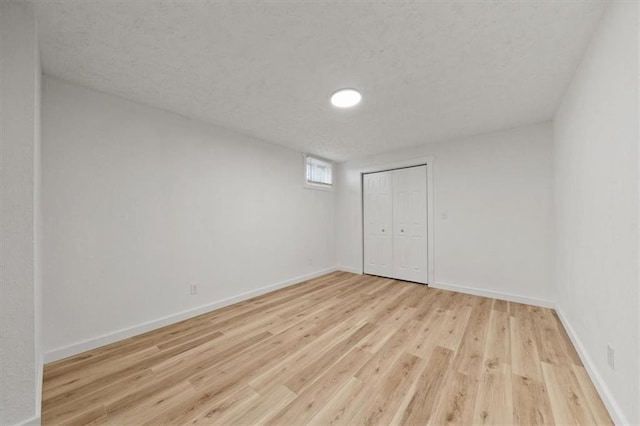 1000 Twin Oaks Ter, Harrisonville, MO 64701 - below grade area with wood finished floors and a textured ceiling