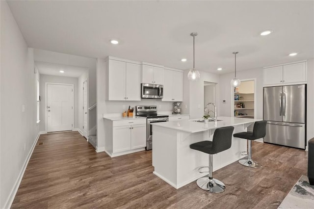 13333 W 180th St, Overland Park, KS 66013 - kitchen featuring stainless steel appliances, recessed lighting, dark wood finished floors, light countertops, and a breakfast bar