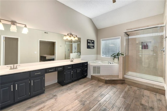 14010 Ash St, Overland Park, KS 66224 - full bath with lofted ceiling, double vanity, a garden tub, wood finished floors, and a stall shower