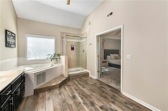 14010 Ash St, Overland Park, KS 66224 - ensuite bathroom with vaulted ceiling, a garden tub, a stall shower, wood finished floors, and vanity