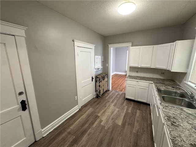 726 N River Blvd, Independence, MO 64050 - kitchen with dark wood-type flooring, white cabinetry, decorative backsplash, and a textured ceiling