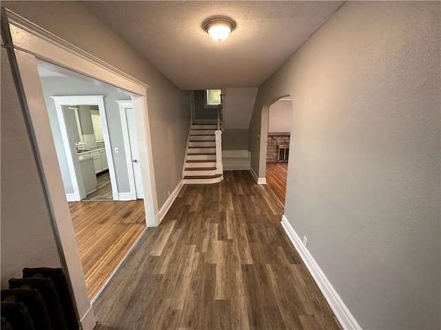 726 N River Blvd, Independence, MO 64050 - corridor featuring stairway, dark wood-type flooring, arched walkways, and a textured ceiling