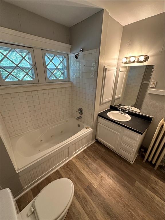 726 N River Blvd, Independence, MO 64050 - full bath featuring wood finished floors, a combined bath / shower with jetted tub, and vanity