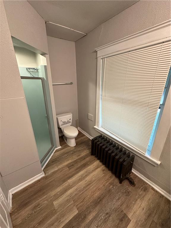 726 N River Blvd, Independence, MO 64050 - full bath featuring radiator, wood finished floors, and a stall shower