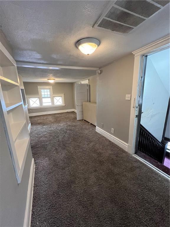726 N River Blvd, Independence, MO 64050 - carpeted empty room with baseboards and a textured ceiling