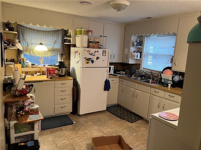 726 N River Blvd, Independence, MO 64050 - kitchen with freestanding refrigerator, open shelves, and a textured ceiling