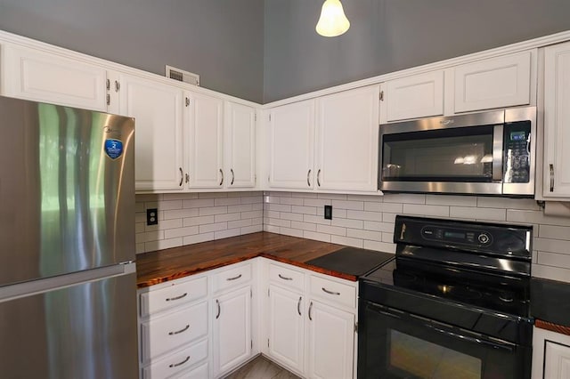 311 NE Bridge Pl, Blue Springs, MO 64014 - kitchen with stainless steel appliances, decorative backsplash, white cabinets, and butcher block countertops