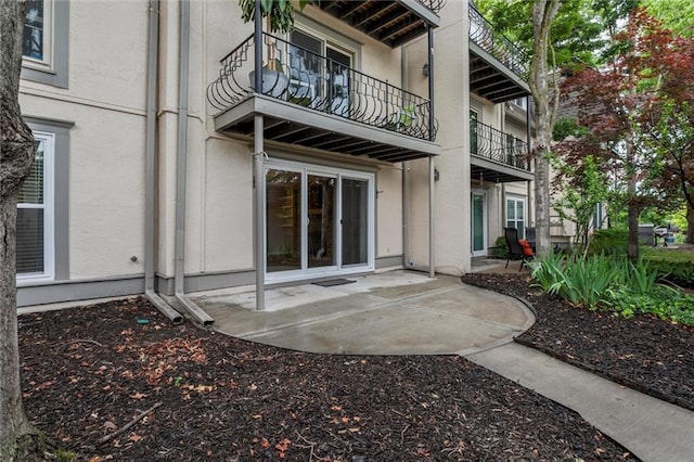 10734 Glenwood St Unit A, Overland Park, KS 66211 - rear view of house featuring a balcony, stucco siding, and a patio