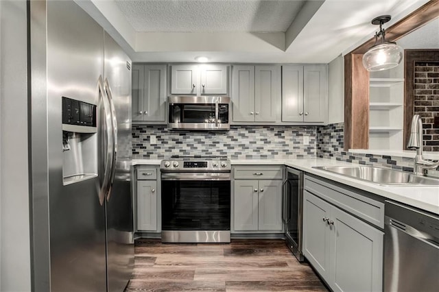 10734 Glenwood St Unit A, Overland Park, KS 66211 - kitchen featuring appliances with stainless steel finishes, gray cabinetry, light countertops, backsplash, and a textured ceiling