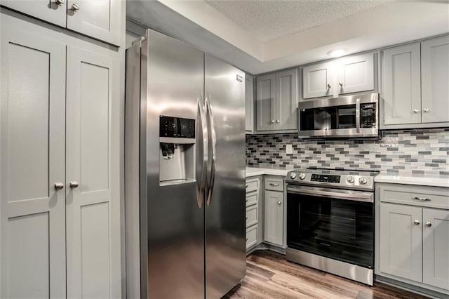 10734 Glenwood St Unit A, Overland Park, KS 66211 - kitchen with appliances with stainless steel finishes, gray cabinets, a textured ceiling, and light countertops