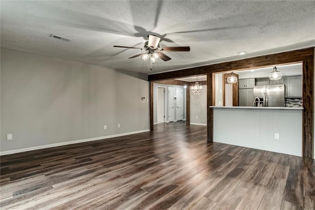 10734 Glenwood St Unit A, Overland Park, KS 66211 - unfurnished living room featuring ceiling fan, dark wood-style flooring, a textured ceiling, and a chandelier