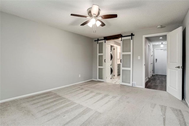 10734 Glenwood St Unit A, Overland Park, KS 66211 - unfurnished bedroom with carpet, a barn door, and a ceiling fan