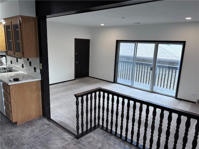 423 W 104th St Unit C, Kansas City, MO 64114 - kitchen featuring light carpet, glass insert cabinets, light countertops, recessed lighting, and decorative backsplash