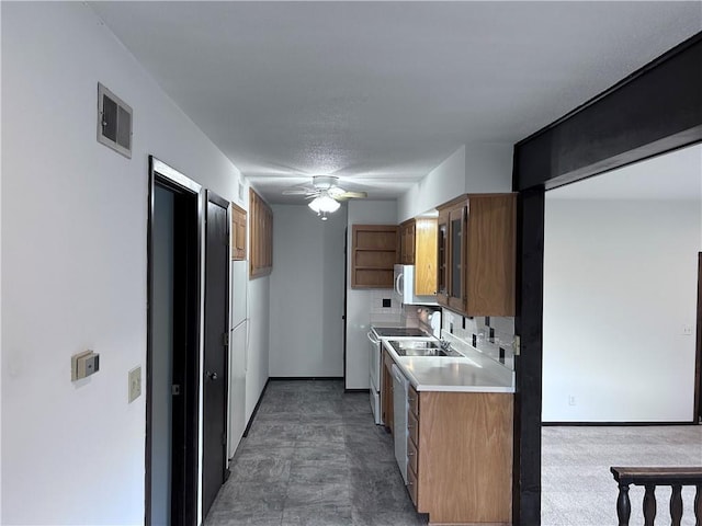 423 W 104th St Unit C, Kansas City, MO 64114 - kitchen with light countertops, ceiling fan, brown cabinets, white appliances, and backsplash