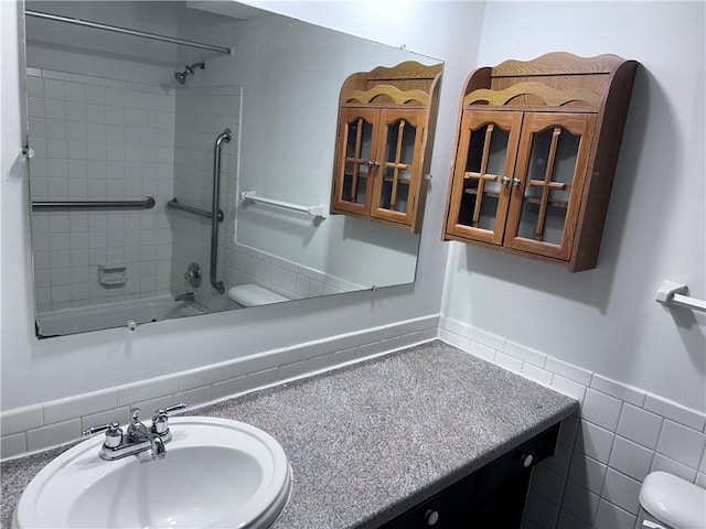 423 W 104th St Unit C, Kansas City, MO 64114 - full bath featuring washtub / shower combination, vanity, tile walls, and wainscoting