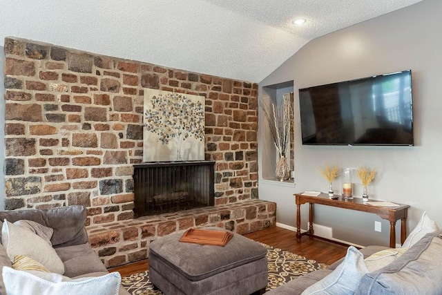 423 W 104th St Unit C, Kansas City, MO 64114 - living area with a textured ceiling, vaulted ceiling, wood finished floors, and a large fireplace