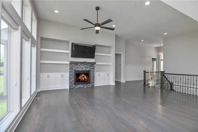 14500 Aurora Ln, Basehor, KS 66007 - unfurnished living room featuring built in features, ceiling fan, dark wood finished floors, a tiled fireplace, and recessed lighting