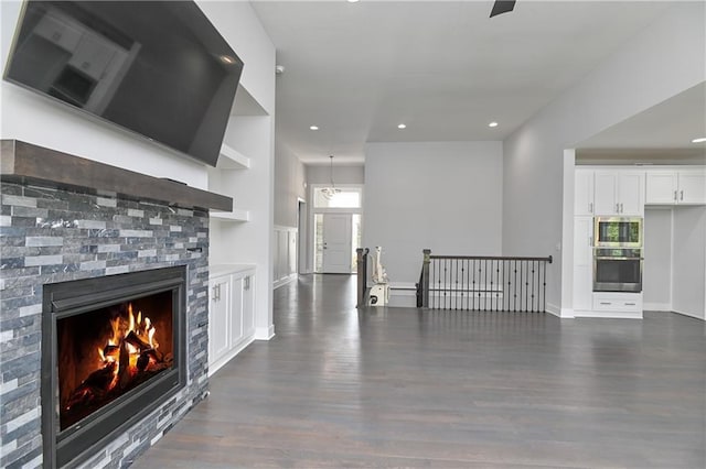 14500 Aurora Ln, Basehor, KS 66007 - unfurnished living room featuring dark wood-type flooring, recessed lighting, and a glass covered fireplace