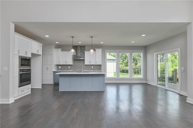 14500 Aurora Ln, Basehor, KS 66007 - kitchen with wall chimney exhaust hood, plenty of natural light, dark wood finished floors, white cabinetry, and recessed lighting